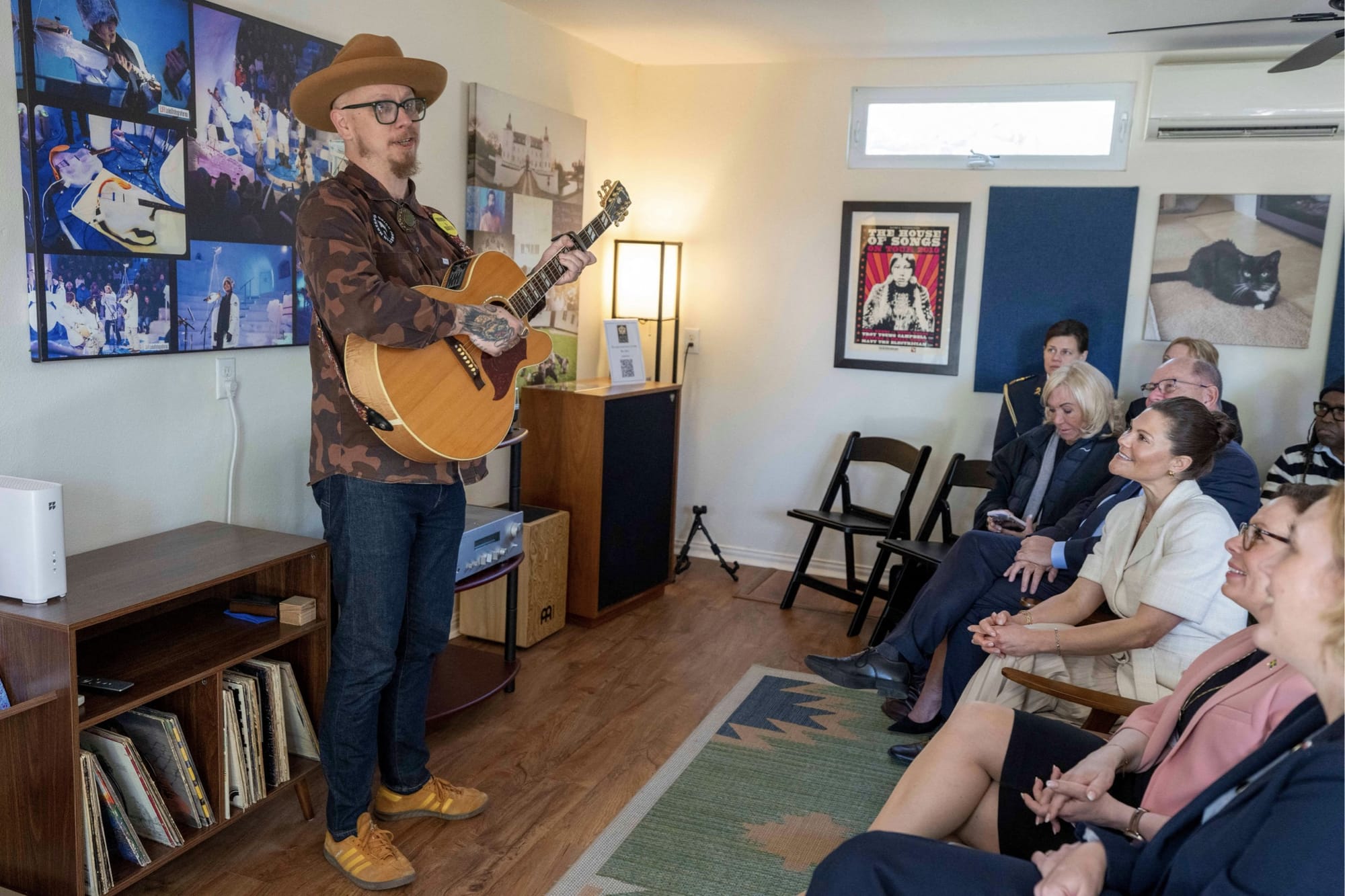 Bild från en intim spelning på House of Songs i Austin, Texas, där kronprinsessan Victoria och utrikesminister Maria Malmer Stenergard sitter i publiken. Svenska musikern Mika Häkki står upp och spelar gitarr.