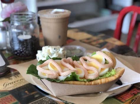 A serving of a sandwich with lettuce and sliced hard-boiled egg covered in a long swirl of Swedish "kaviar", a pinkish, salty fish-egg paste.