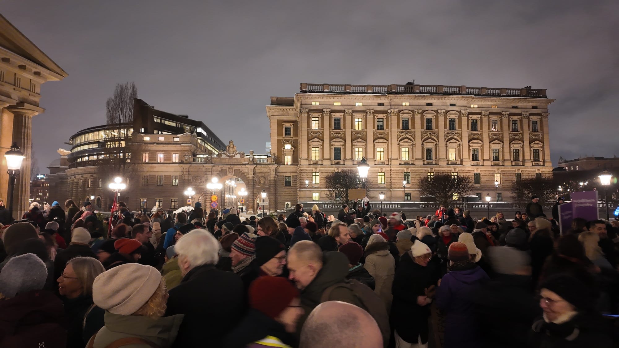 Folkmassa på Mynttorget i vinterkyla med riksdagshuset i bakgrunden.