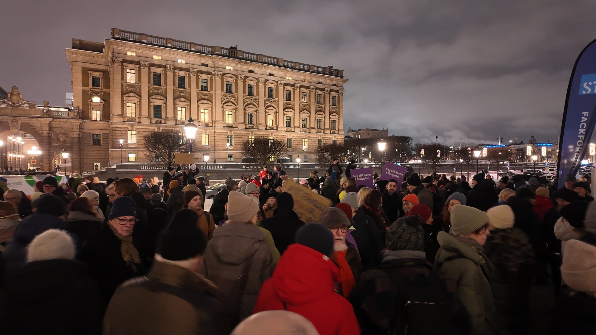Folkmassa på Mynttorget i vinterkyla med riksdagshuset i bakgrunden.