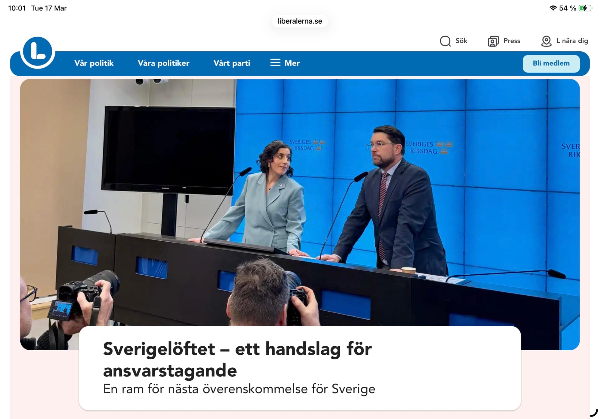 Skärmdump från Liberalernas hemsida med en nyhet högst upp med bild från den senaste presskonferensen den 13 mars. Nyhetsrubriken är ”Sverigelöftet – ett handslag för ansvarstagagande: En ram för nästa överenskommels för Sverige. Bilden visar att ögonblick när Jimmie Åkesson står med händerna på podiet och tittar majestätiskt ut över åhörarna, och bredvid står Mohanmsson med blicken fäst vid Åkesson, i vad som lätt uppfattas som en beundrande blick.