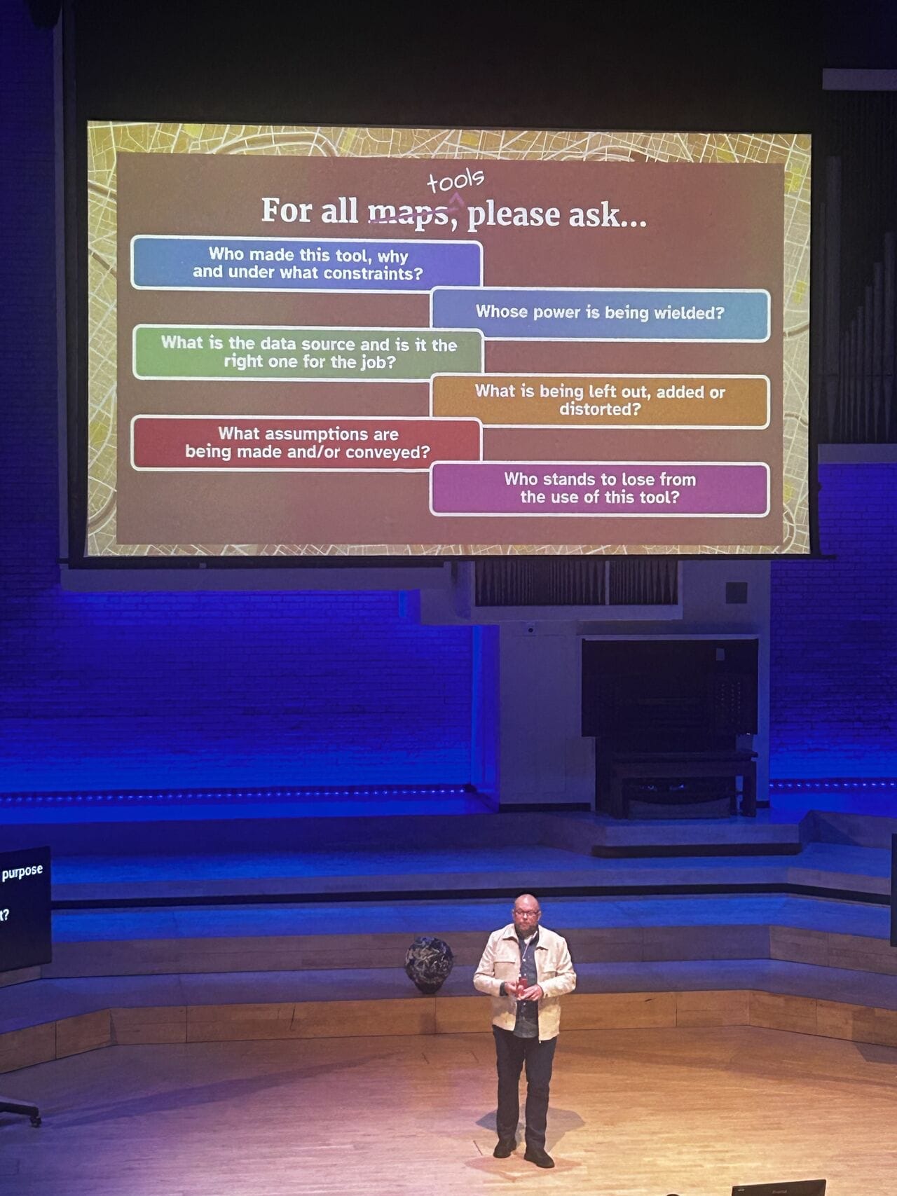 Per Axbom on stage in front of a world map explaining what to questions to ask about maps, and any tool used for explanation.

- Who made this tool, why and under what constraints?
- Whose power is being wielded?
- What is the data source is it the right one for the job?
- What is being left out, added or distorted?
- What assumption are being made and/or conveyed?
- Who stands to lose from the use of this tool?
